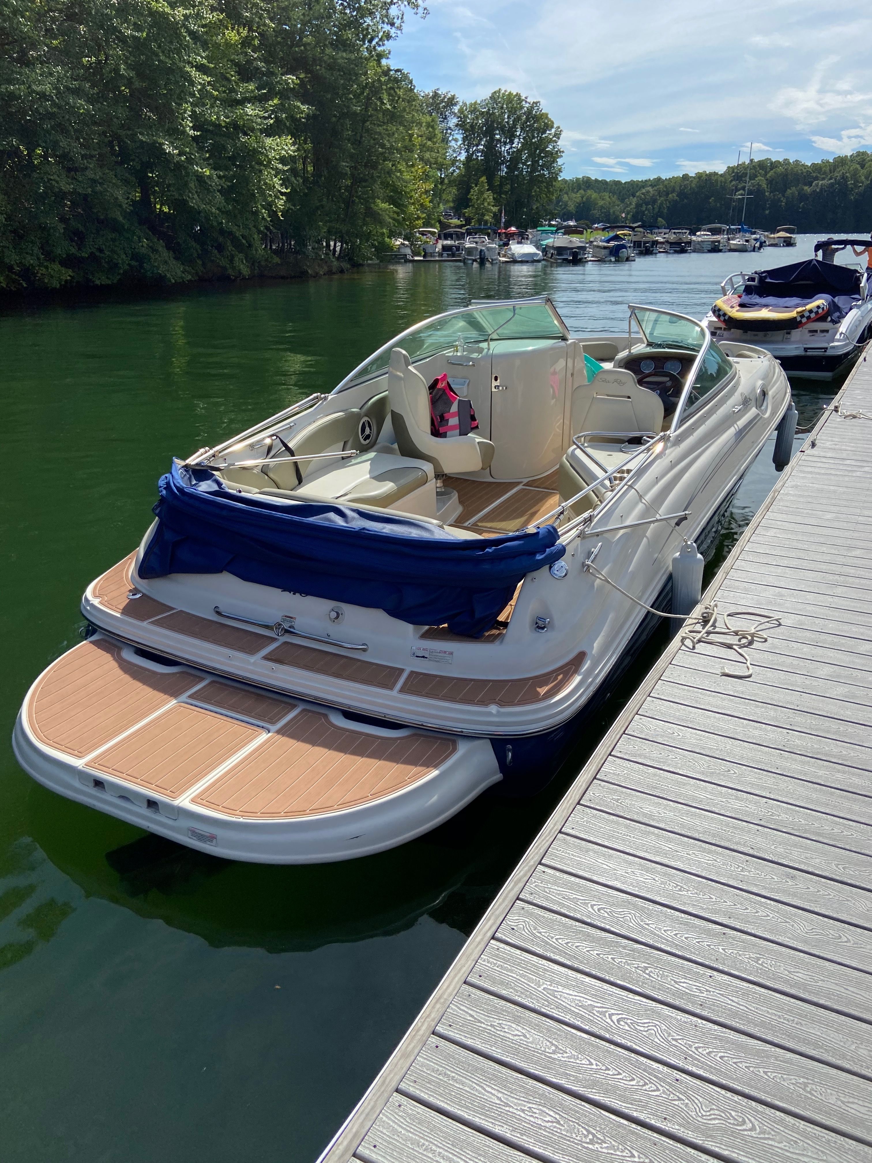 Sea Ray 240 Sundeck 2007 Sea Ray 240 Sundeck boat docked on a serene lake with lush greenery.