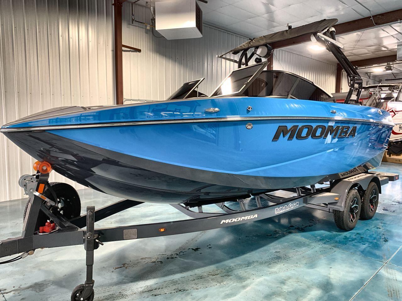 Moomba Craz 2025 Moomba Craz boat in blue, displayed indoors on a trailer.