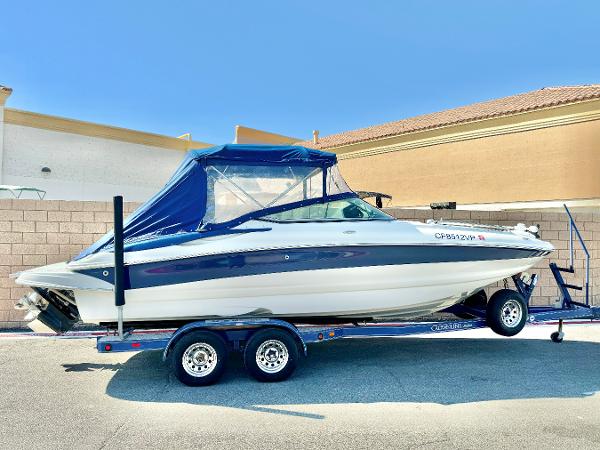 Crownline 240 EX 2006 Crownline 240 EX boat on trailer with blue canopy.