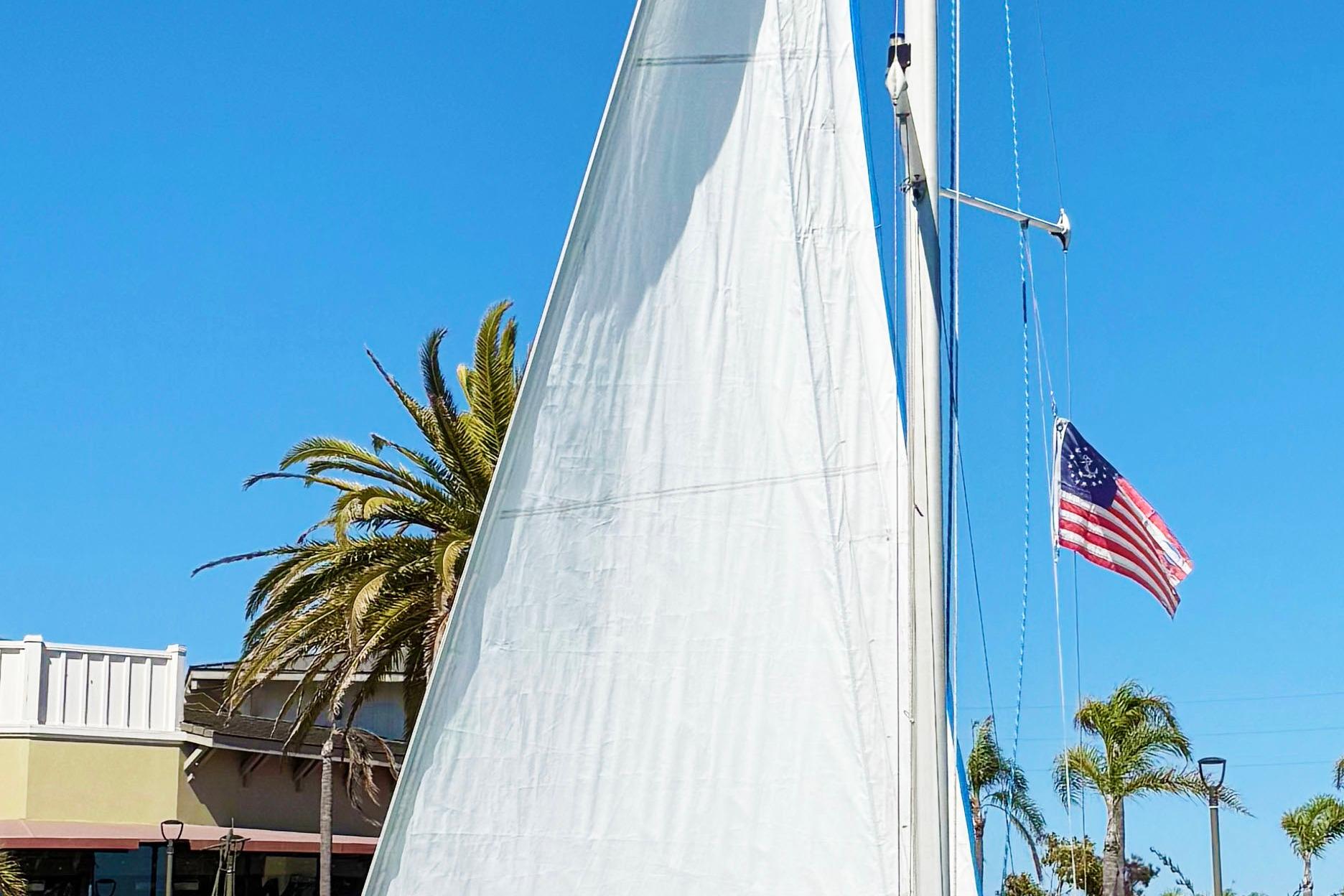 Catalina 22 Capri Catalina 22 Capri sailboat with American flag, palm trees, and clear blue sky.