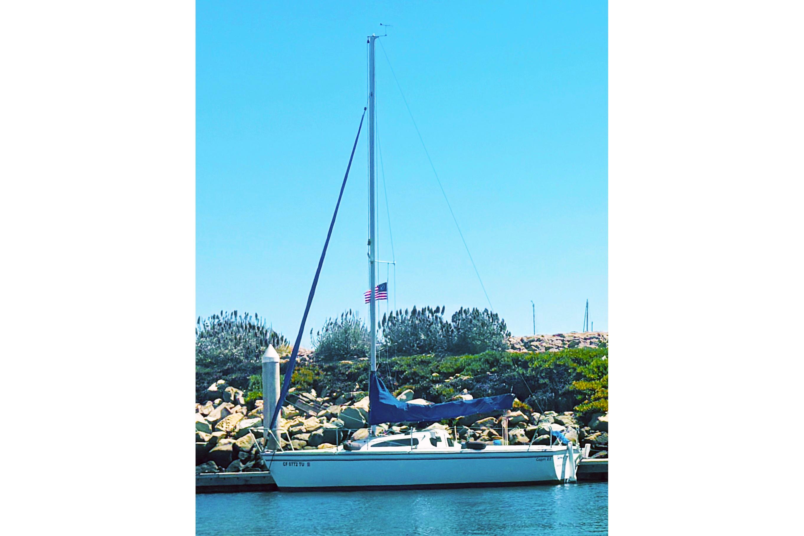 Catalina 22 Capri Catalina 22 Capri sailboat docked by rocky shoreline, clear blue sky, 2002 model.