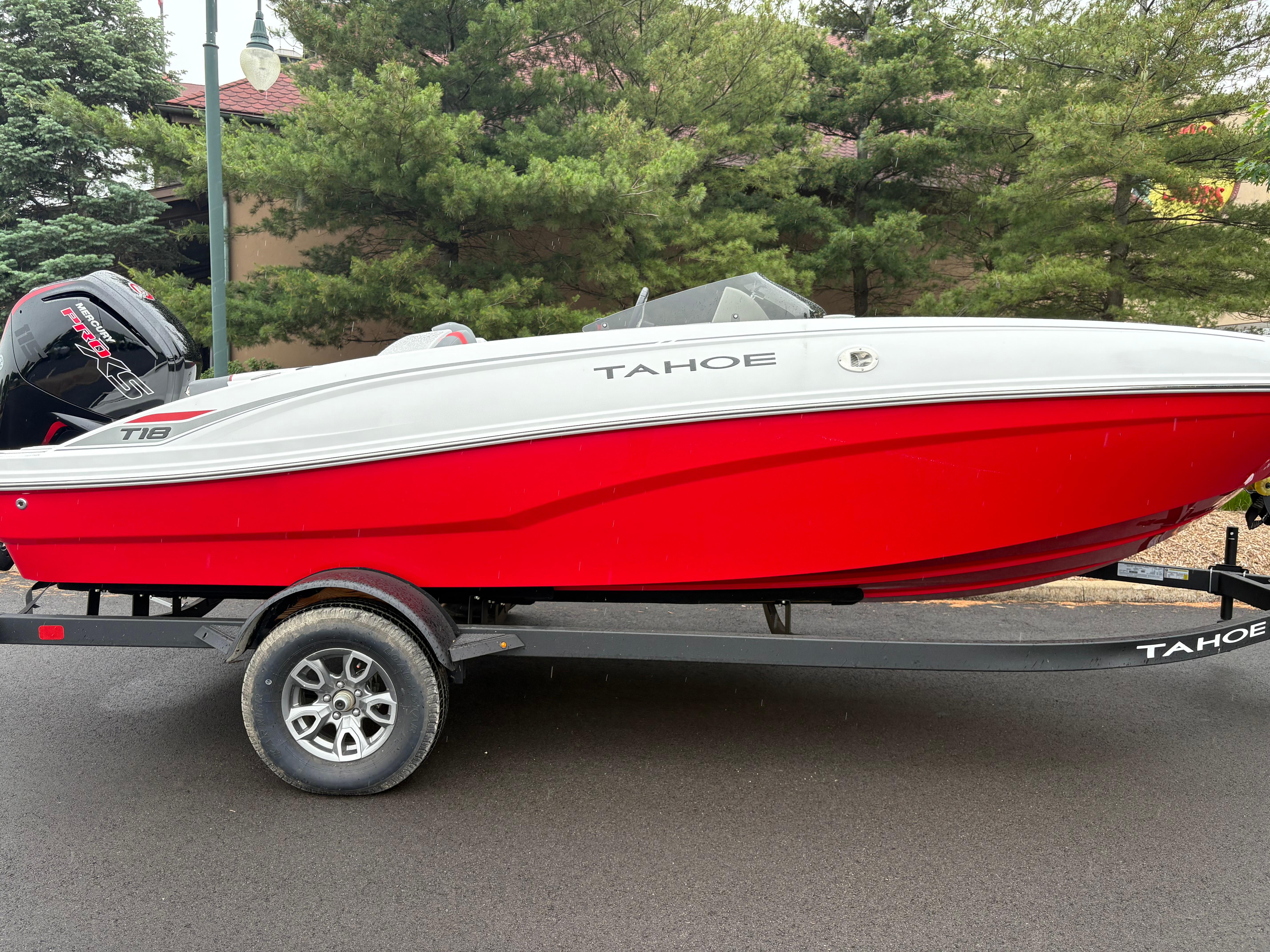 Tahoe T18 2025 Tahoe T18 boat in red and white on a trailer, parked outdoors.