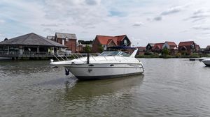 Maxum 3000 SCR 1999 Maxum 3000 SCR boat on a calm river with houses in the background.