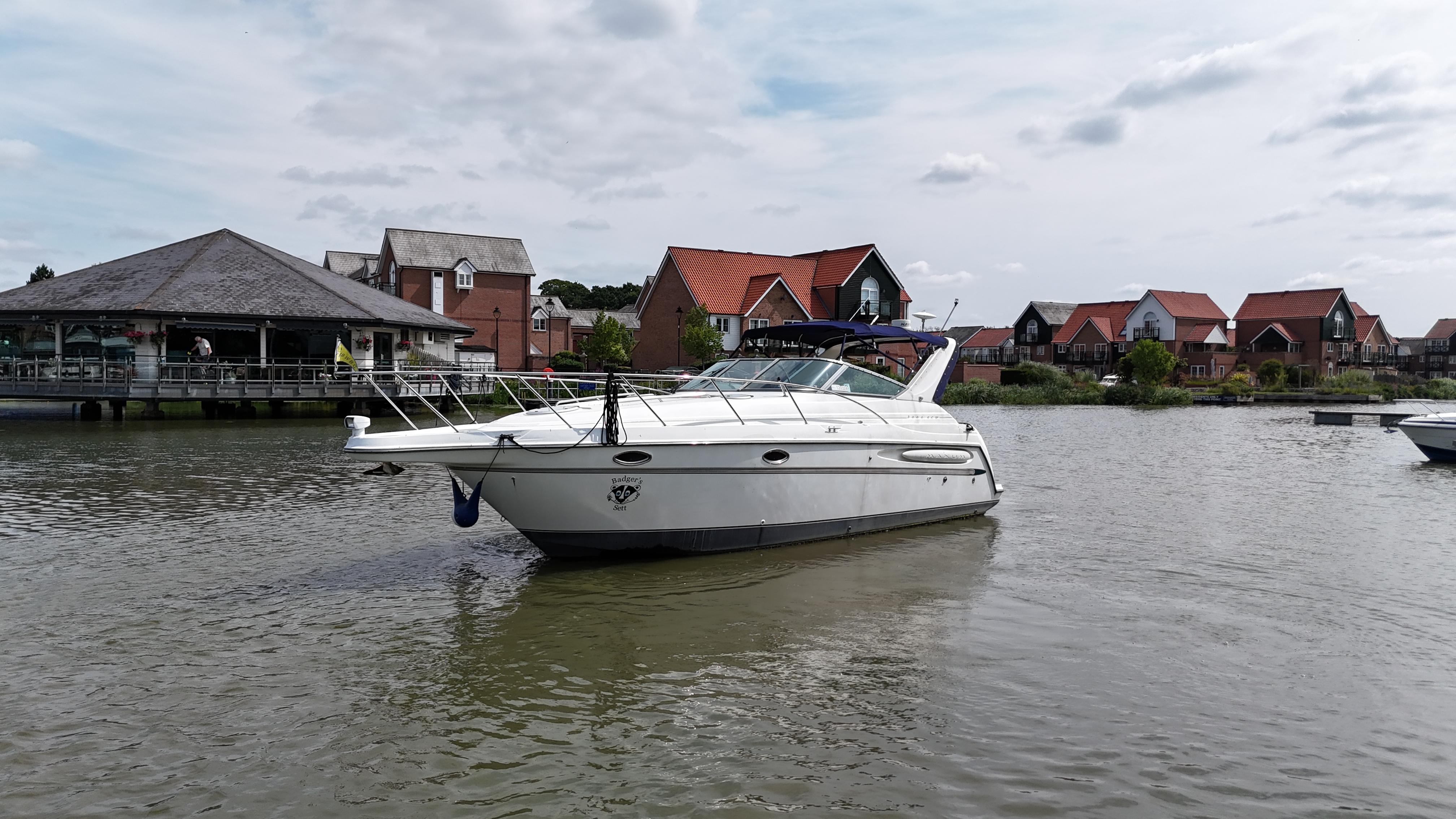 Maxum 3000 SCR 1999 Maxum 3000 SCR boat on a calm river with houses in the background.