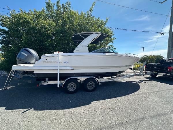 Chaparral 270 OSX 2023 Chaparral 270 OSX boat on trailer, parked outdoors under clear sky.