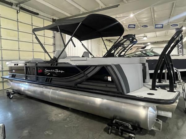 South Bay 500 2025 South Bay 500 pontoon boat in showroom, featuring sleek design and canopy.