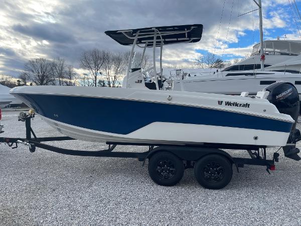 Wellcraft 202 Fisherman 2023 Wellcraft 202 Fisherman boat on trailer, blue and white design, parked outdoors.