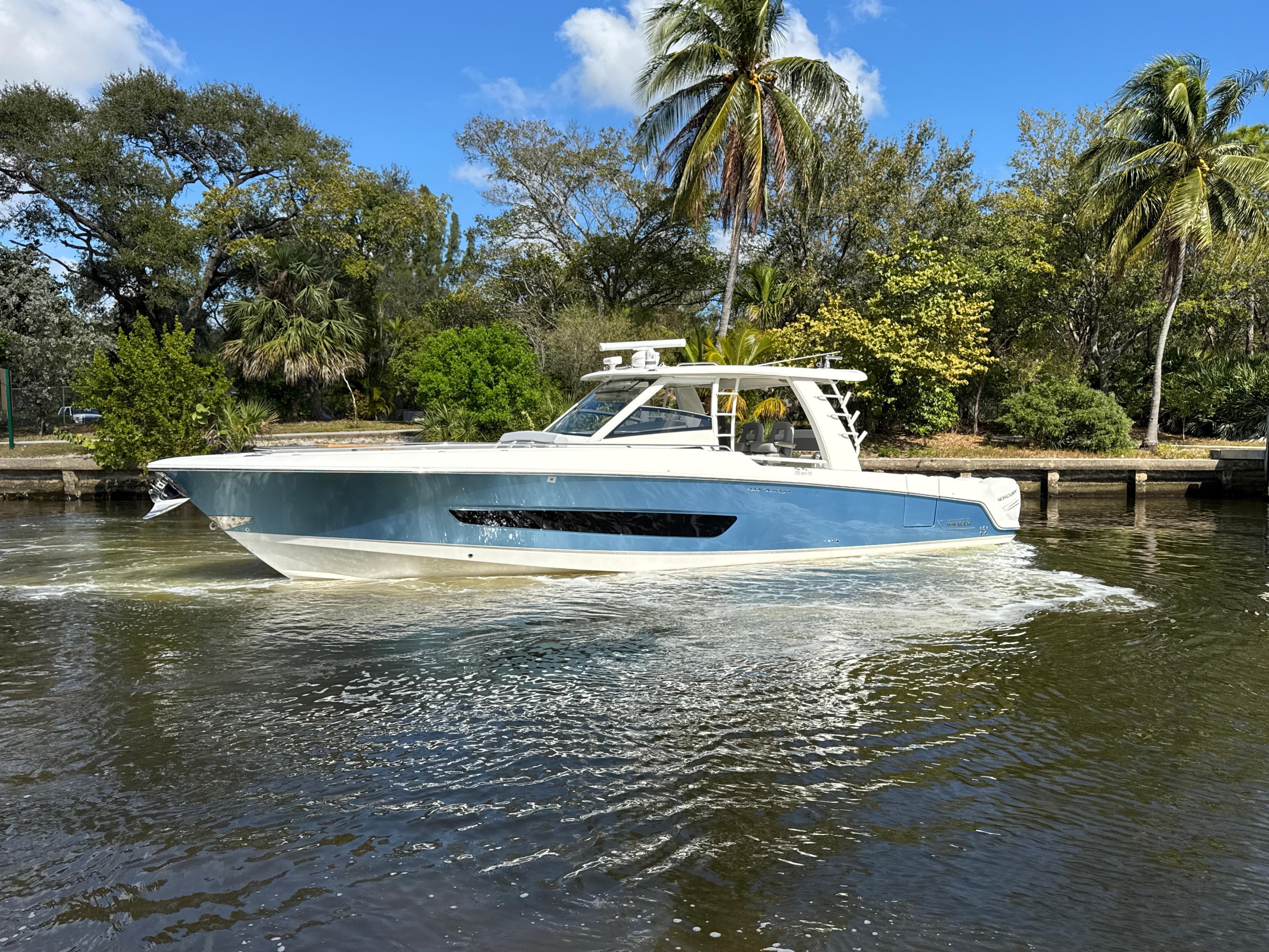 Boston Whaler 420 Outrage 2016 Boston Whaler 420 Outrage boat cruising on a scenic waterway with lush greenery.