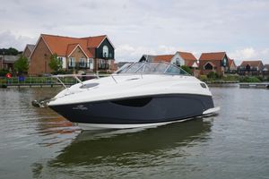 Regal 28 Express 2022 Regal 28 Express boat on calm water near modern houses.