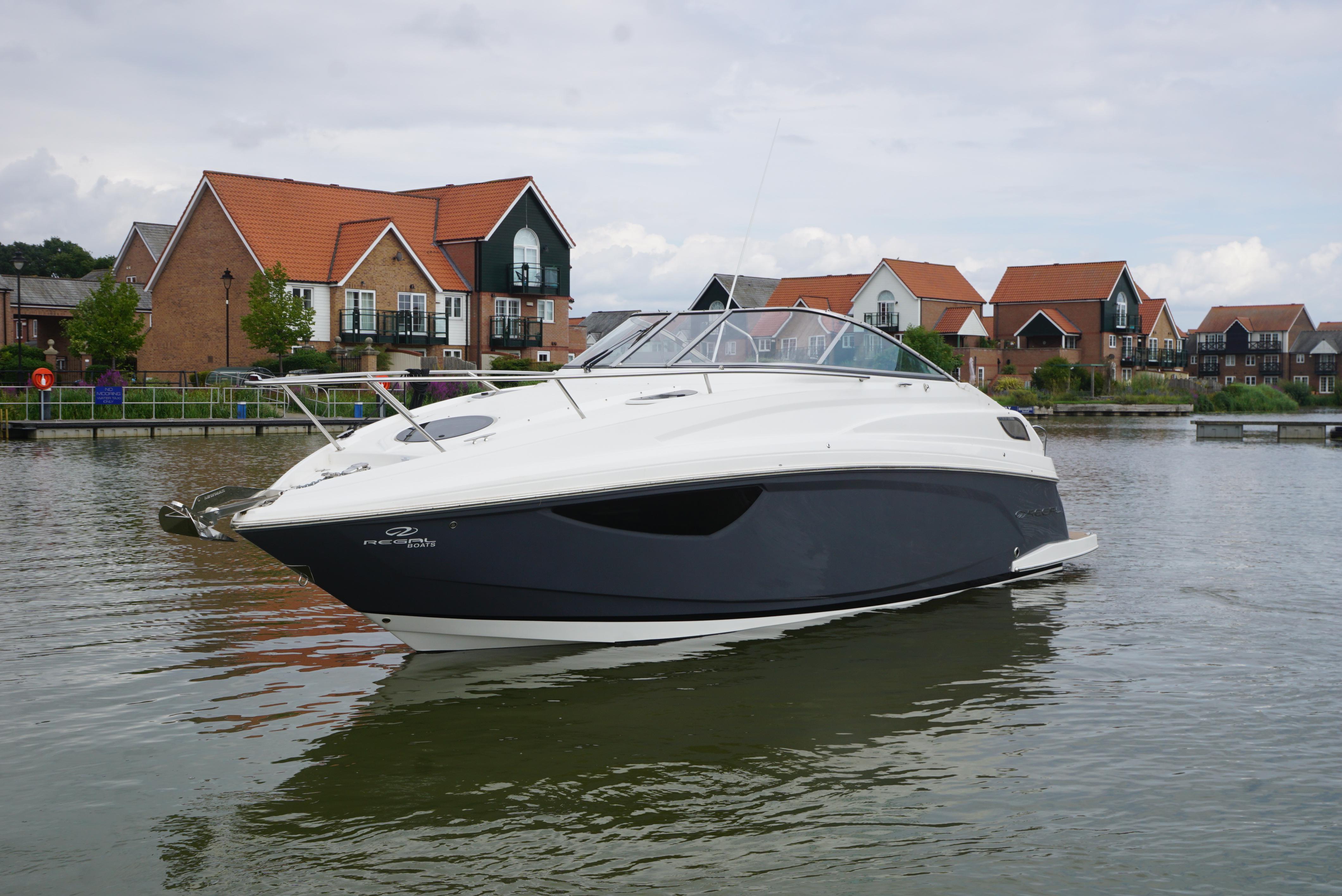 Regal 28 Express 2022 Regal 28 Express boat on calm water near modern houses.