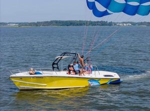 Centurion Flight 33 Parasail Boat Yellow Centurion parasail boat on water, 2010 model, with people parasailing.