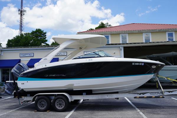 Regal LX4 2023 Regal LX4 boat on trailer in parking lot, sunny day.