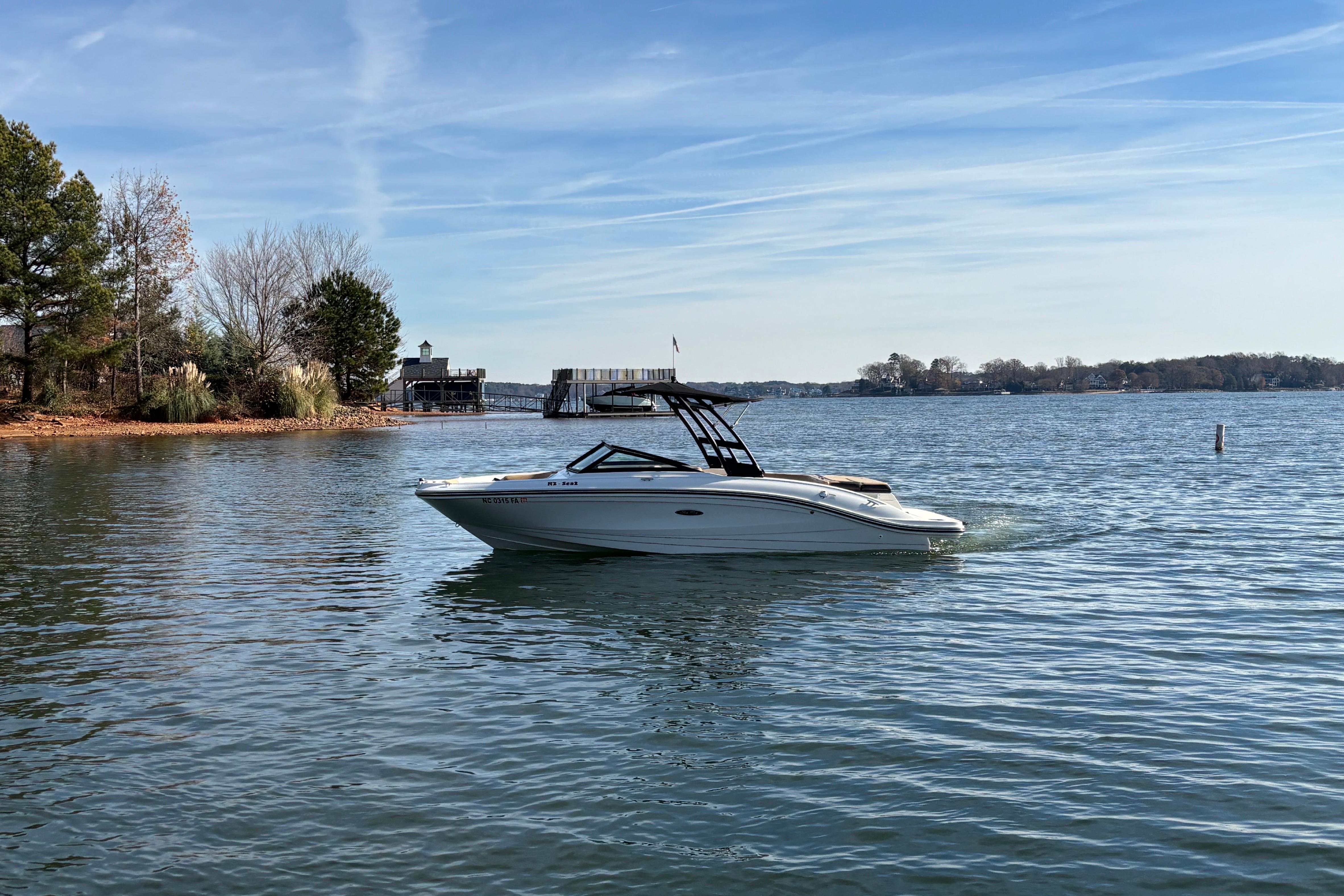 Sea Ray SPX 210 2023 Sea Ray SPX 210 boat cruising on a serene lake with trees in the background.