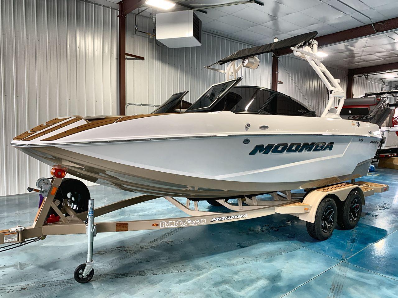Moomba Mondo 2025 Moomba Mondo boat on trailer in indoor showroom.