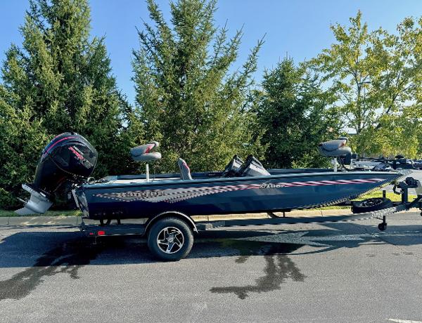 Ranger RT198P 2024 Ranger RT198P boat on trailer, parked outdoors, surrounded by trees.
