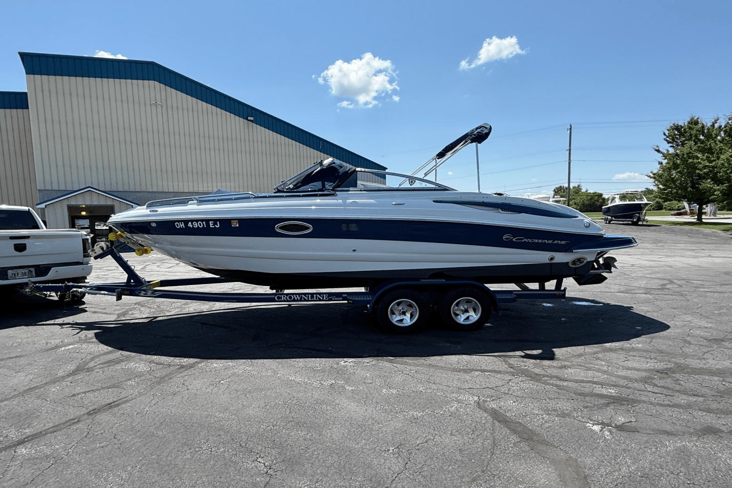 Crownline 240 LS 2008 Crownline 240 LS boat on trailer, parked outdoors under clear blue sky.