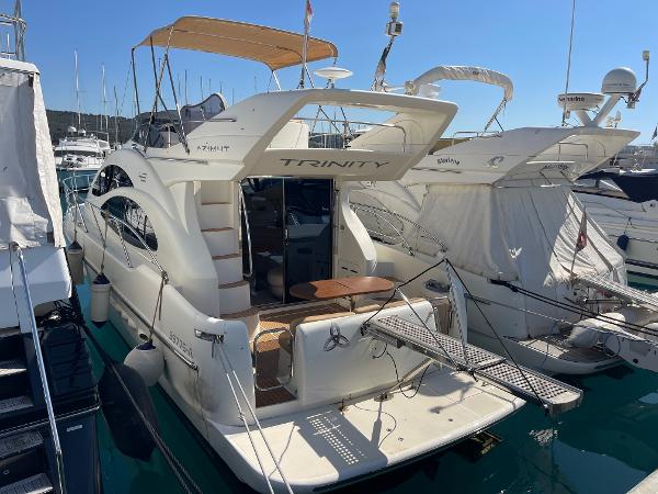 Azimut 42 2004 Azimut 42 yacht docked in marina, featuring spacious deck and elegant design.
