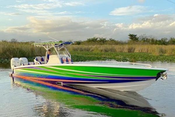 Concept 36' Cuddy Cabin 2020 Concept 36' Cuddy Cabin boat with vibrant green and blue design on calm water.