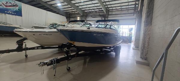 Sea Ray SPX 230 2023 Sea Ray SPX 230 boat in showroom, on trailer, side view.