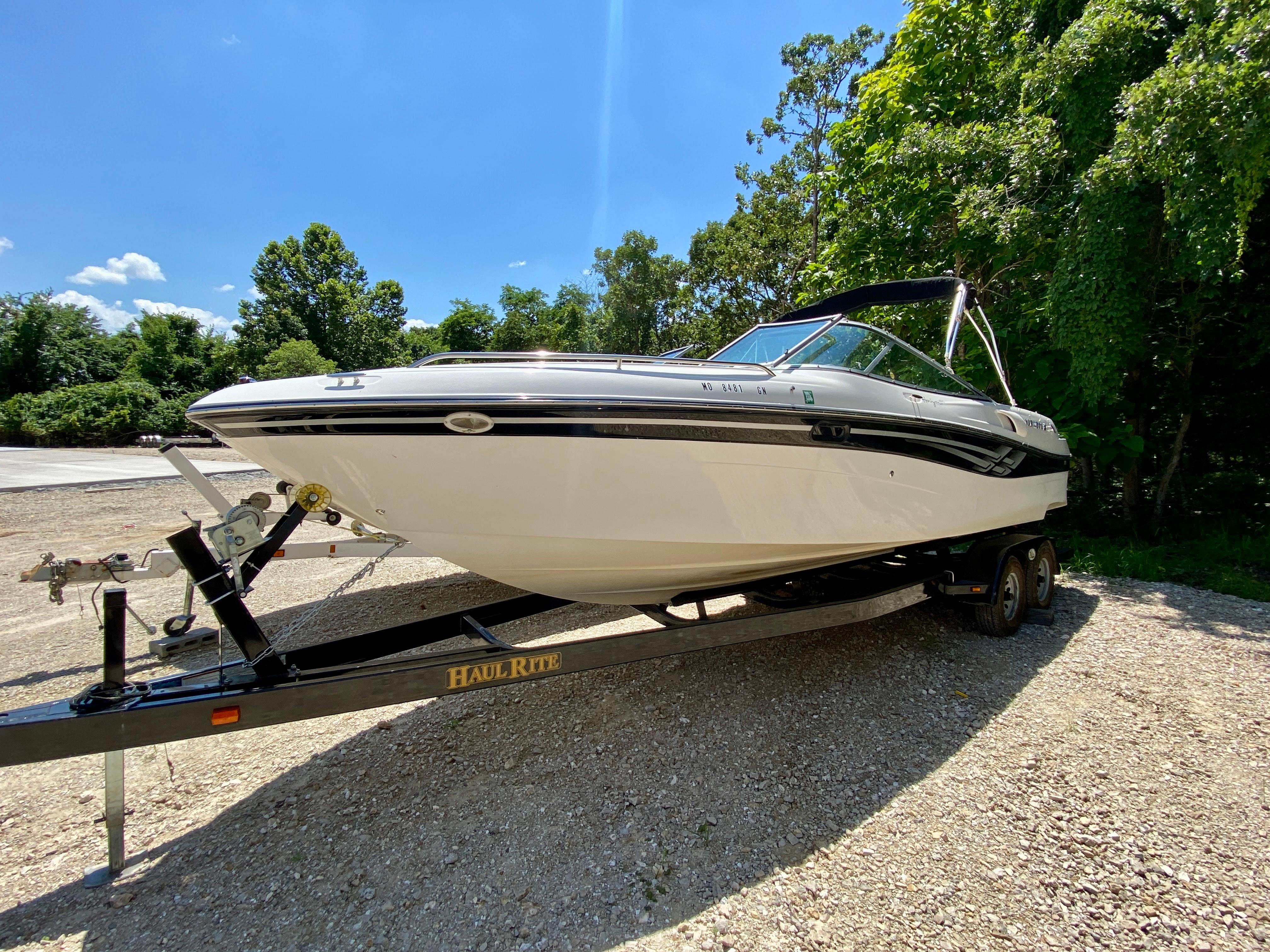 Four Winns 260 Horizon 2000 Four Winns 260 Horizon boat on trailer, parked outdoors, surrounded by trees.