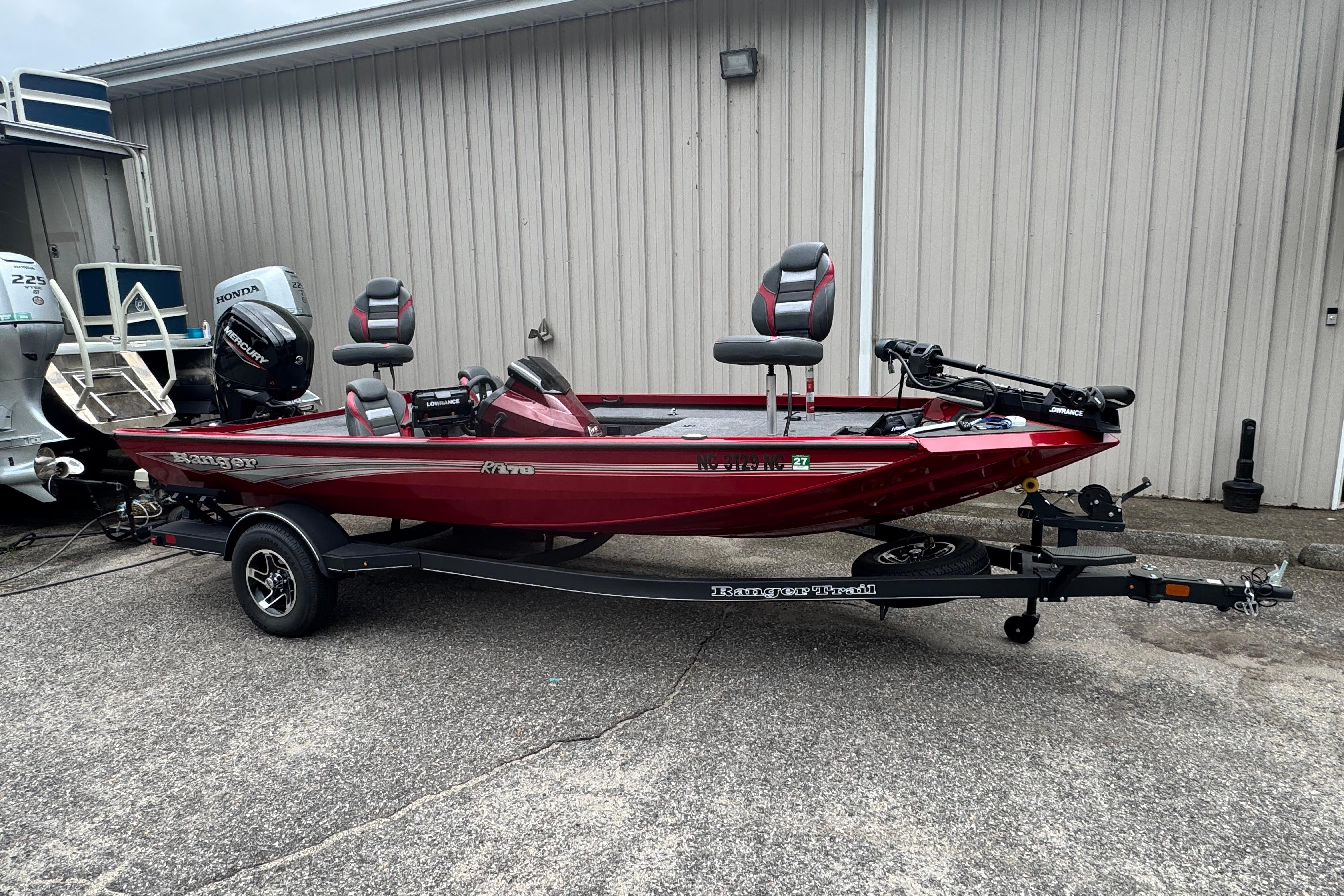 Ranger RT178 2024 Bass Tracker RT178 boat in red on a trailer, parked outdoors.