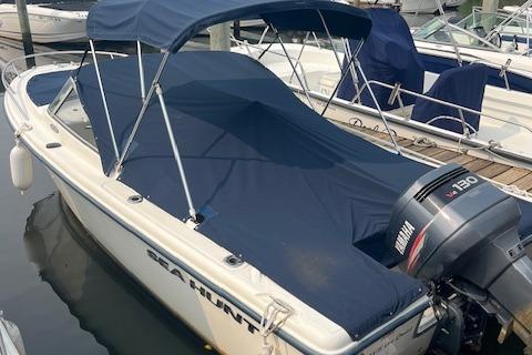Sea Hunt Escape 200 2001 Sea Hunt 19 Dual Console boat with Yamaha 130 engine, docked with blue cover.