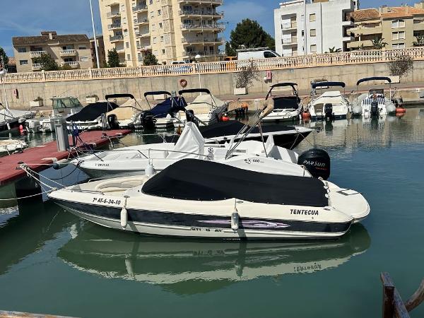 Stingray 205LX 2010 Stingray 205LX boat docked in a marina with other vessels.