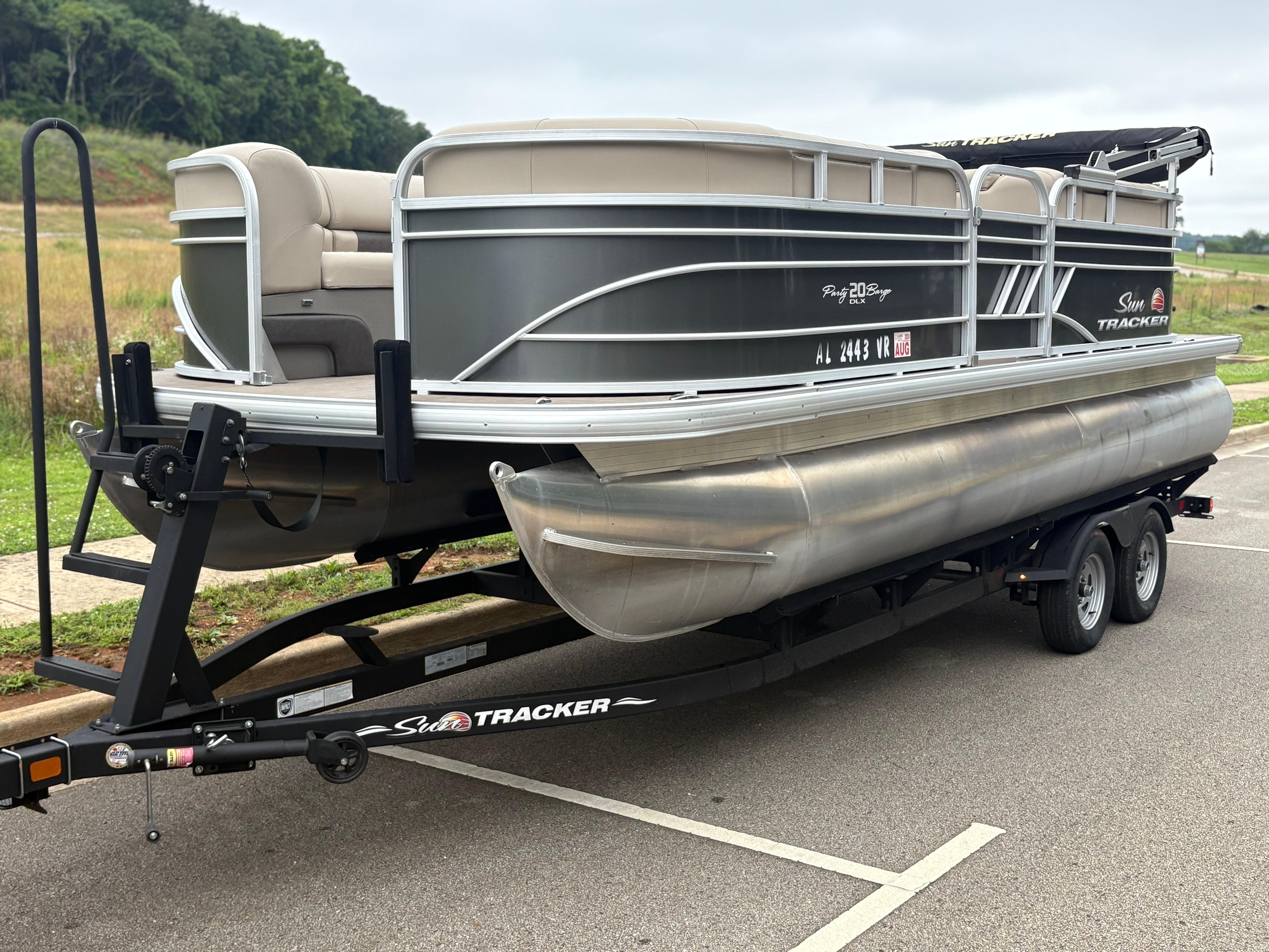 Sun Tracker Party Barge 20 DLX 2022 Sun Tracker Party Barge 20 DLX pontoon boat on trailer in parking lot.