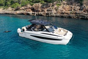 Aquila 32 Sport 2023 Aquila 32 boat anchored in clear blue water near rocky coastline.