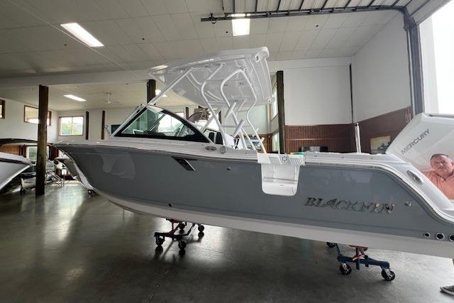 Blackfin 252 DC 2026 Blackfin 252 DC boat in showroom, side view, gray and white design.