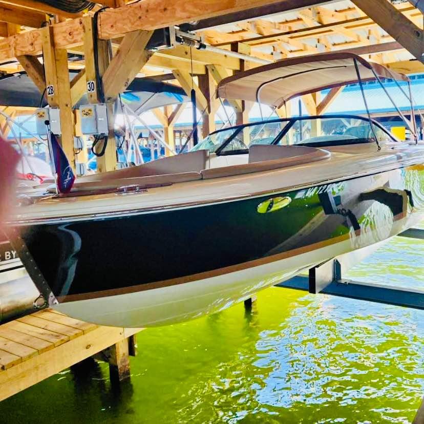 Chris-Craft Carina 21 2016 Chris-Craft Carina 21 boat docked in a wooden boathouse.