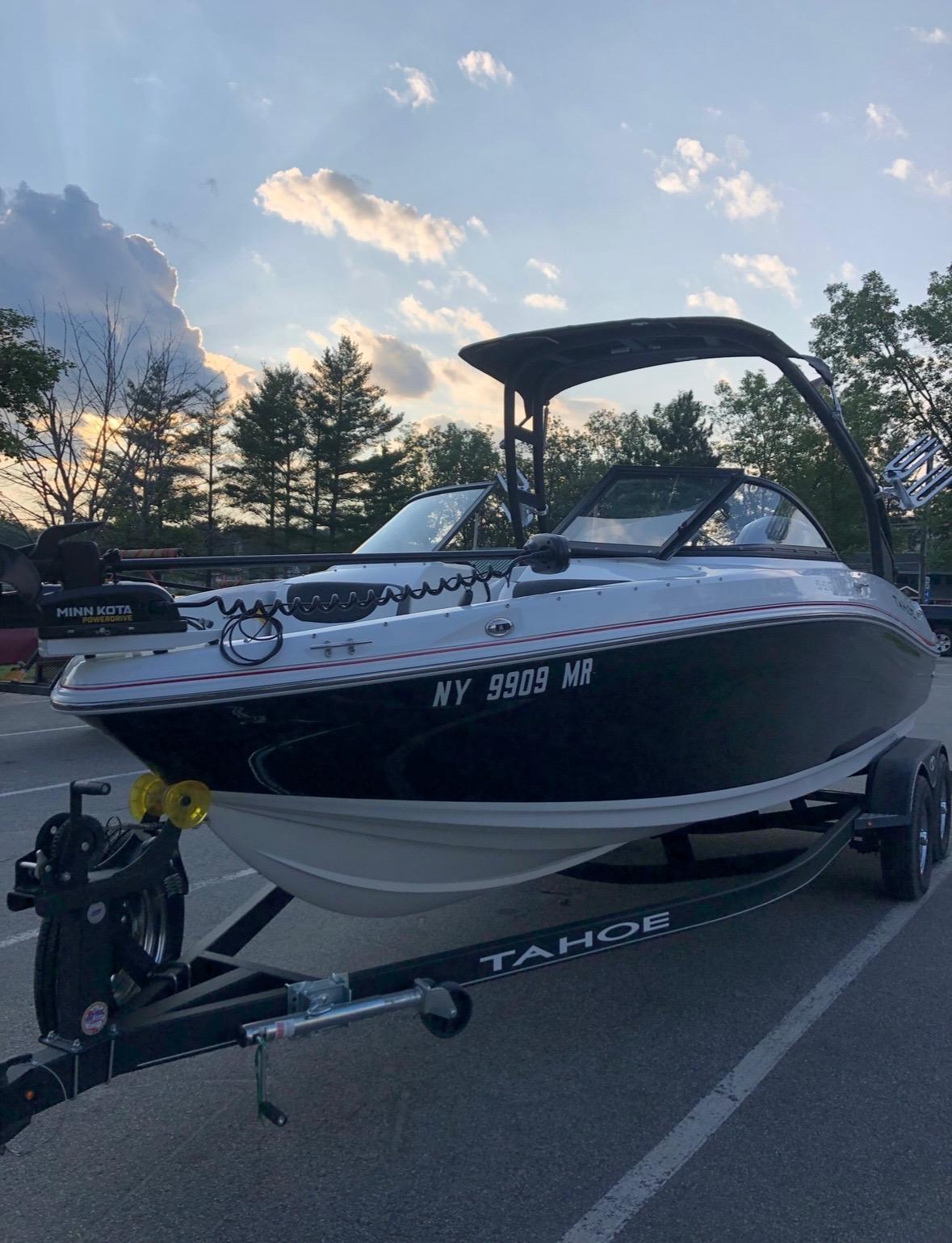 Tahoe 550 TF 2021 Tahoe 550 TF boat on trailer at sunset, parked in a scenic area.