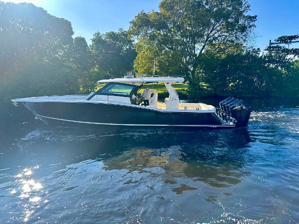 Scout 425 LXF 2025 Scout 425 LXF boat cruising on a sunny day, surrounded by lush greenery.