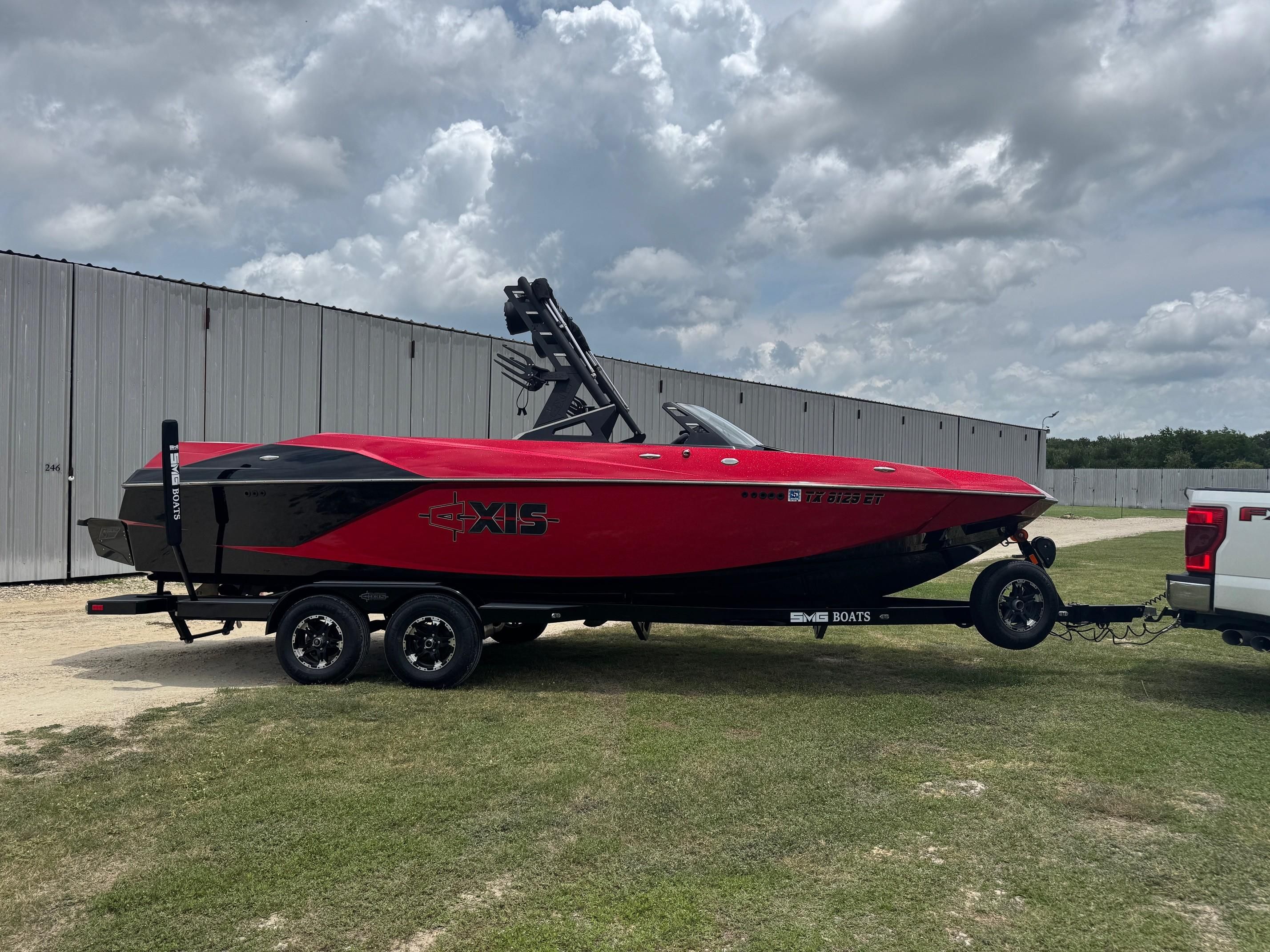Axis A24 2019 Axis A24 boat in red and black on a trailer, parked outdoors.