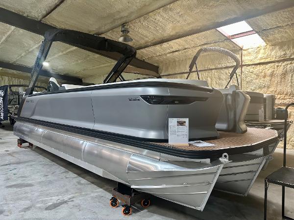 Manitou 26 EXPLORE SWITCHBACK WITH TRIFOLD BENCH 2023 Manitou 26 Explore Switchback pontoon boat with trifold bench in indoor storage.