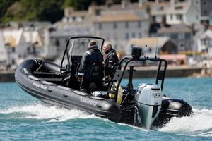 Highfield 660 Patrol 2025 Highfield 660 Patrol boat cruising near coastal town, featuring powerful outboard motor.