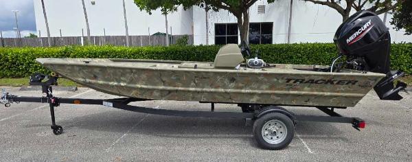 Tracker Grizzly 1648 SC 2025 Tracker Grizzly 1648 SC boat on trailer, camo design, parked outdoors.