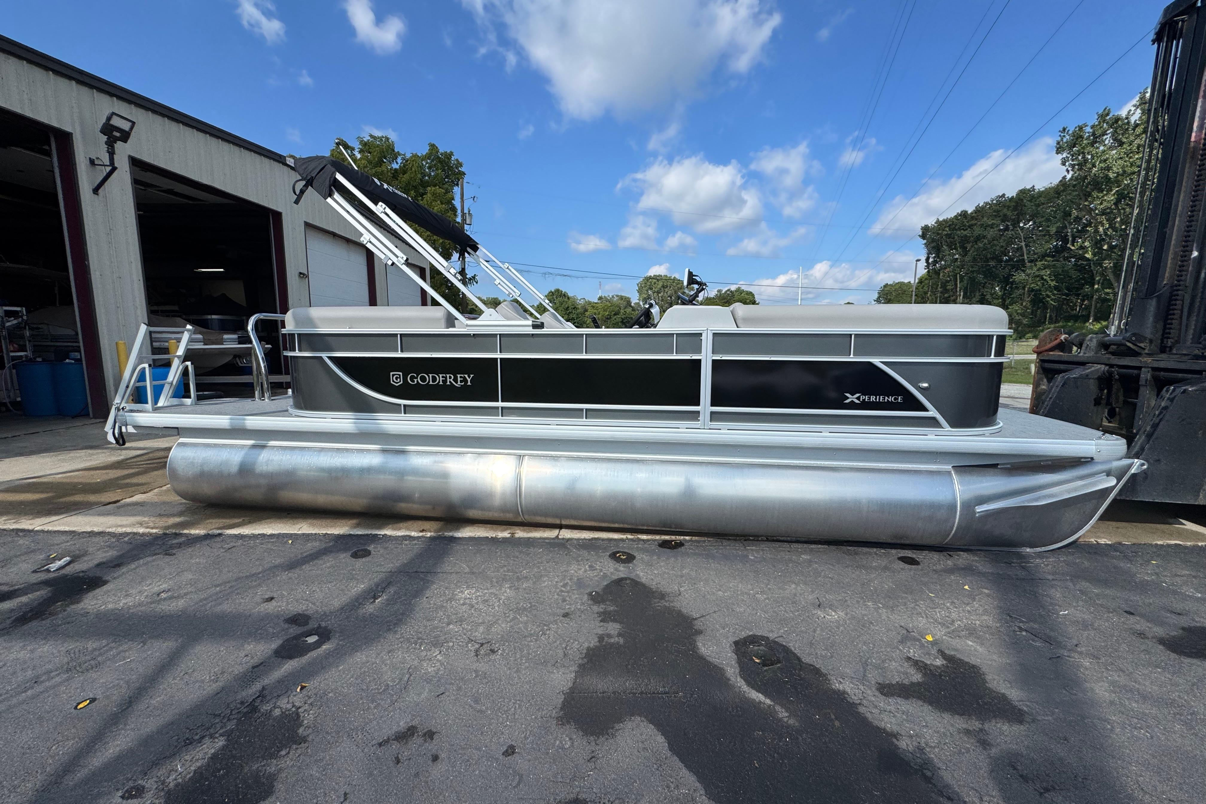 Sweetwater EX2286SBX 2026 Sweetwater EX2286SBX pontoon boat docked outside under blue sky.