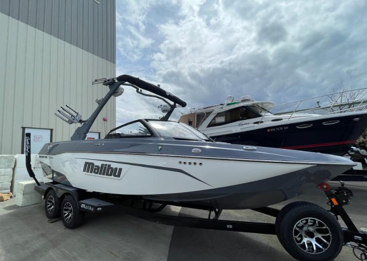 Malibu Wakesetter 23 LSV 2022 Malibu Wakesetter 23 LSV boat on trailer, parked outdoors under cloudy sky.