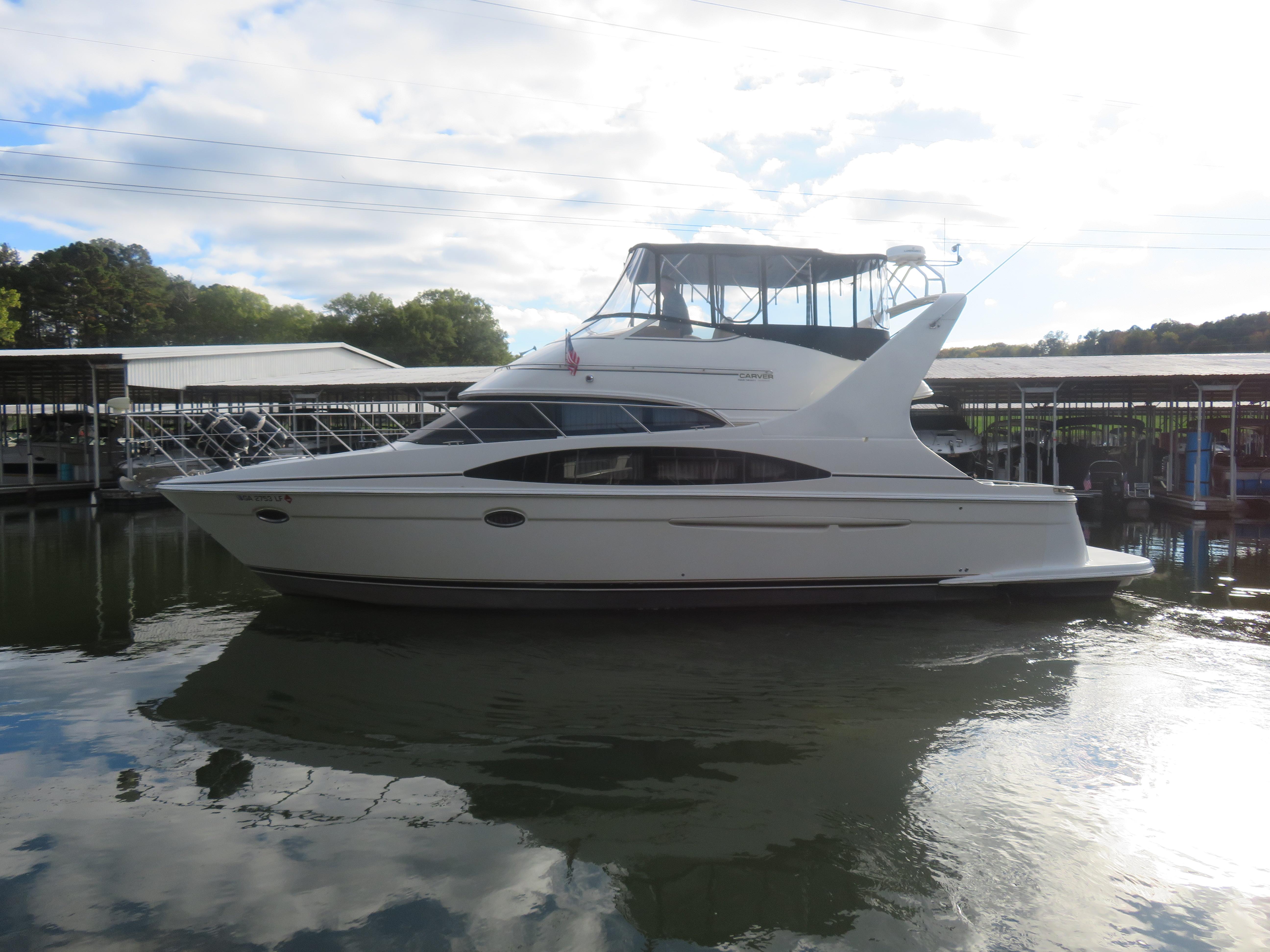 Carver 420 Mariner 2004 Carver 420 Mariner yacht docked on calm water under a partly cloudy sky.