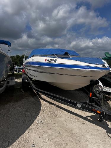 Glastron GT 205 2009 Glastron GT 205 boat on trailer with blue cover under cloudy sky.
