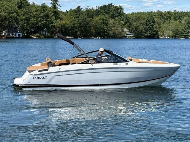 Cobalt R4 2026 Cobalt R4 boat cruising on a serene lake with lush green trees.