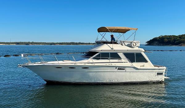 Sea Ray 355T Trawler 1982 Sea Ray 355T Trawler cruising on a calm lake under a clear blue sky.