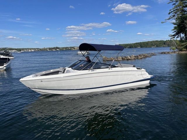Cobalt R6 2026 Cobalt R6 boat on a serene lake under a clear blue sky.