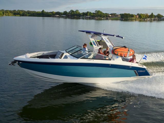 Cobalt R8 Surf 2025 Cobalt R8 Surf boat cruising on a calm lake with passengers onboard.