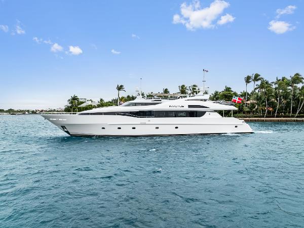 Palmer Johnson 123 Motor Yacht Palmer Johnson 2006 motor yacht cruising on blue water with palm trees in the background.