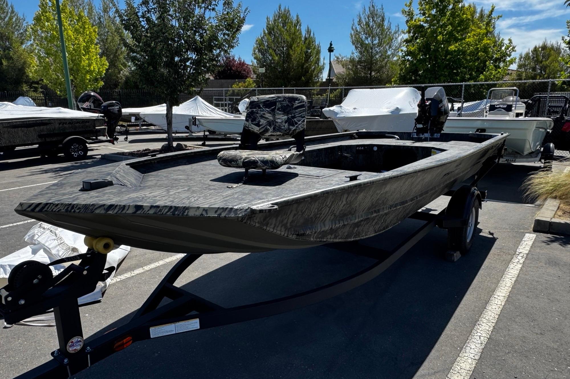 Tracker Grizzly 1654 T Sportsman 2026 Tracker Grizzly 1654 T Sportsman boat on trailer in parking lot.