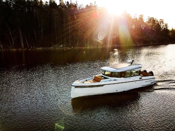 Saxdor 320 GTC 2025 Saxdor 320 GTC cruising on a serene lake at sunset, surrounded by trees.