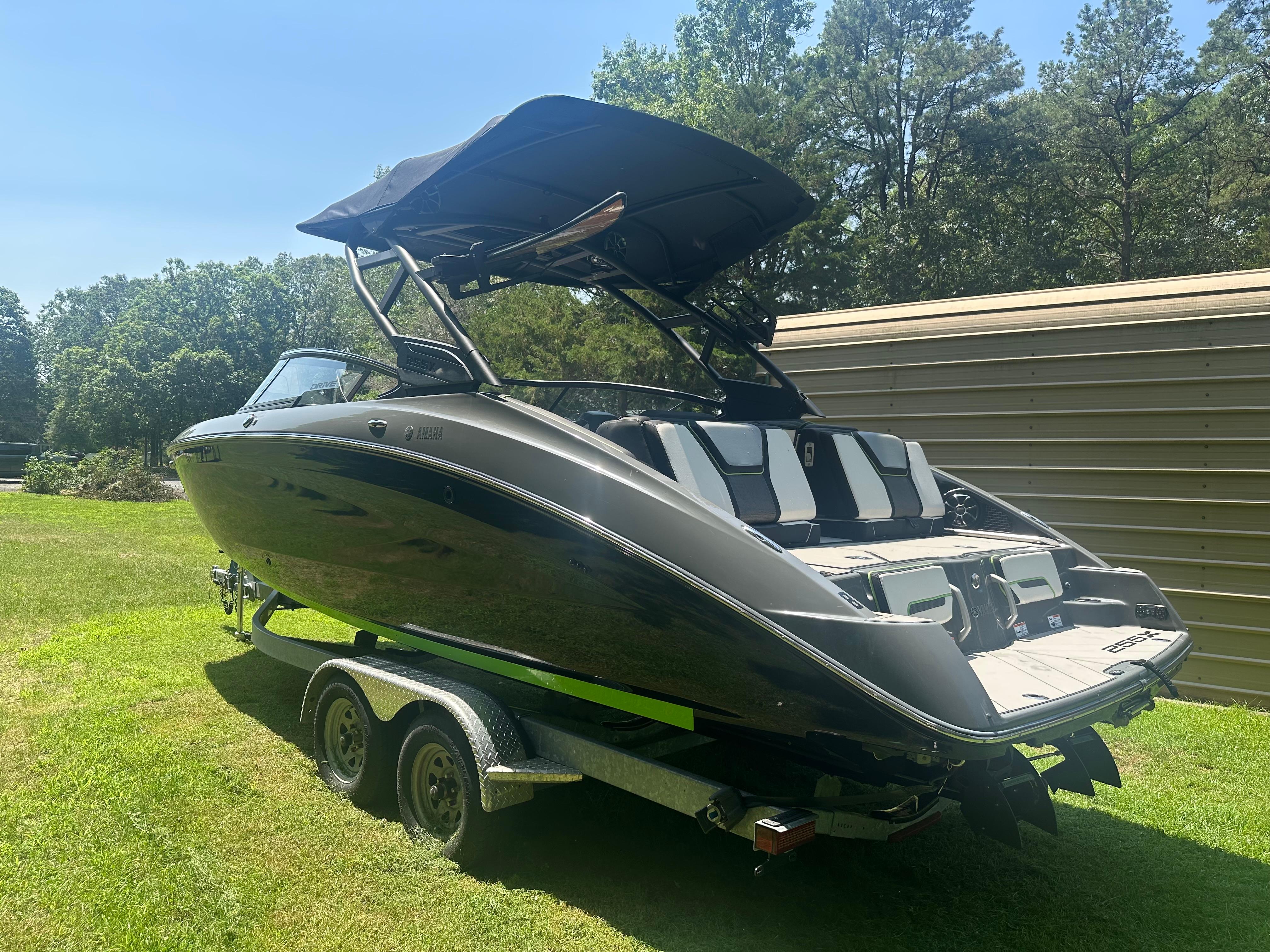 Yamaha Boats 255XD 2021 Yamaha Boats 255XD on trailer, parked on grass, with trees in background.