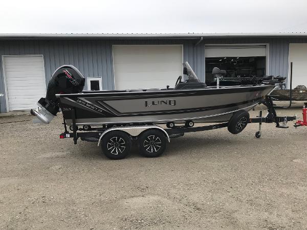 Lund 1875 Impact XS SS 2025 Lund 1875 Impact XS SS boat on trailer, parked outside a garage.